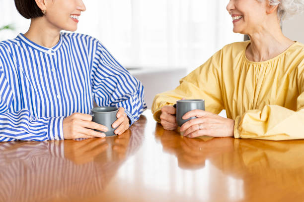 istock Two Asian women are sitting on chairs and talking. 1681636997