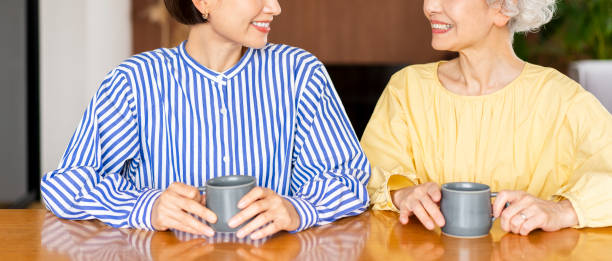 istock Two Asian women are sitting on chairs and talking. 1681637007