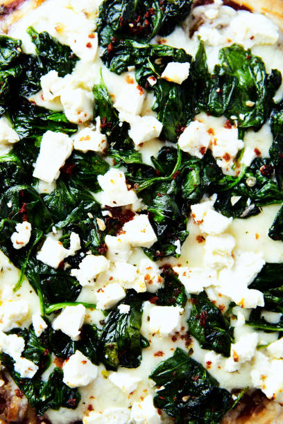 istock Pizza with mozzarella cheese, spinach and fresh basil. Top view. Close up. 1681704239