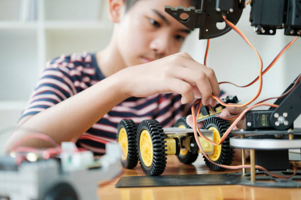 Asian teenager doing robot project in science classroom. technology of robotics programing and STEM education concept. stock photo