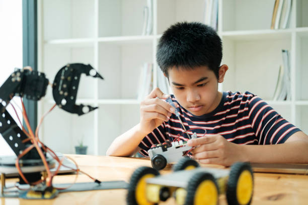istock Asian teenager doing robot project in science classroom. technology of robotics programing and STEM education concept. 1681716937