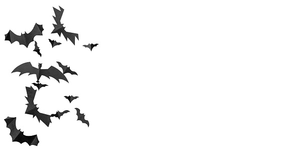 Black paper bats flying over white background.