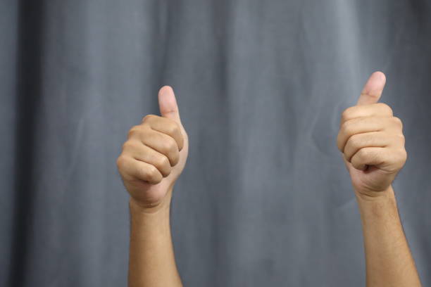 istock Two male hands showing thumbs up on a gray background with copy space 1681769554