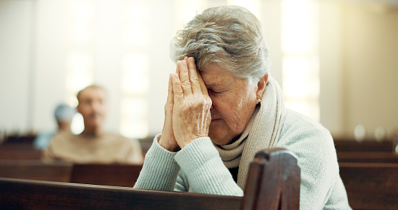 Worship, praying or old woman in church for God, holy spirit or religion in cathedral or Christian community. Faith, spiritual or elderly person in chapel sanctuary to praise Jesus Christ with hope