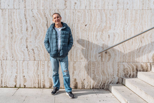 istock Portrait positive middle-aged man against background marble wall with steps 1681770755