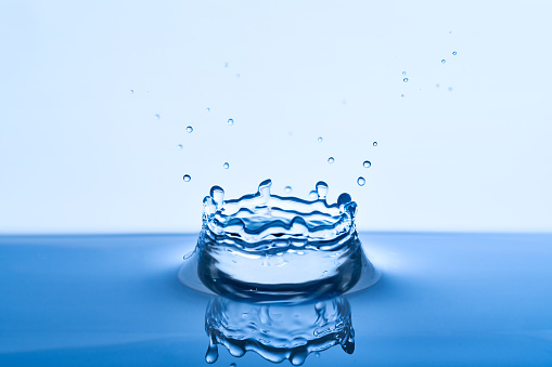 Group of water droplets fall and bounce on a water surface