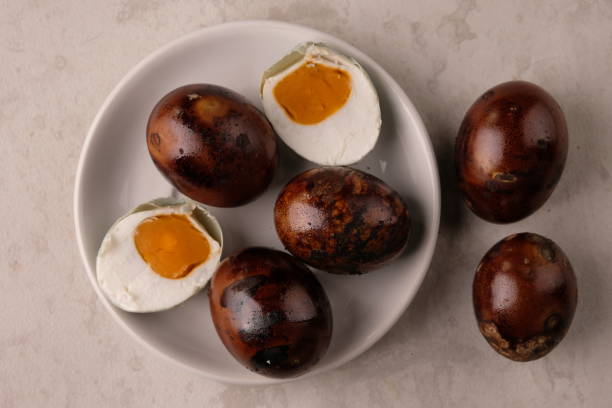 istock telur asian bakar is grilled salted egg on white plate. Salted eggs are duck eggs preserved by soaking in salt water. Indonesian food. 1681833473