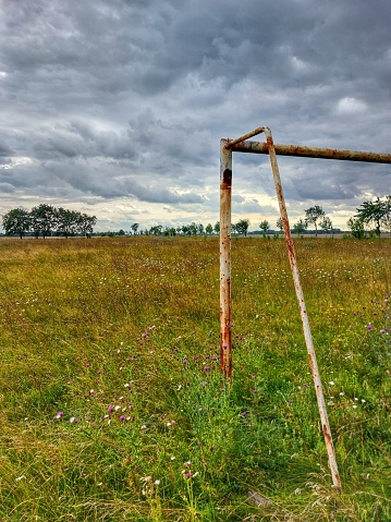 Abandoned soccer field under sky with stormclouds in Germany.