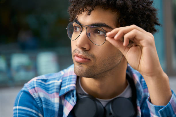 istock Handsome middle eastern man wearing eyeglasses looking away sitting on street 1681883377