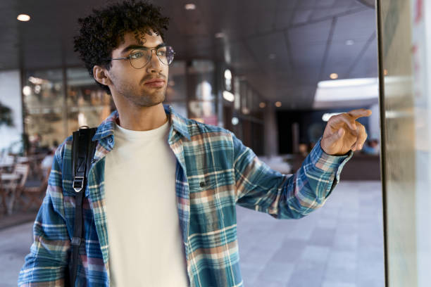 istock Pensive man ordering food pointing on digital display. Pensive Middle Eastern tourist searching way 1681884261