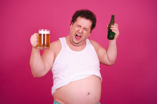 istock Funny fat man is engaged in vacation at sea drinking beer. 1681909576