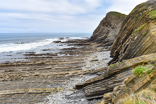 Gipuzkoa, Spain - 14 August, 2021:  Flysch rock formations in the Basque Coast UNESCO Global Geopark between Zumaia and Deba, Spain