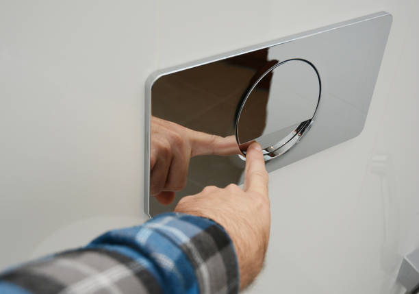 istock A man is pressing a wall-mounted polished chrome single flush plate to flush the toilet. 1681948315