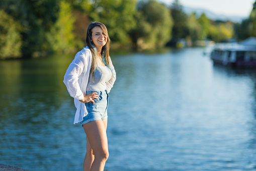 Woman standing at Ljubljanica River bank.