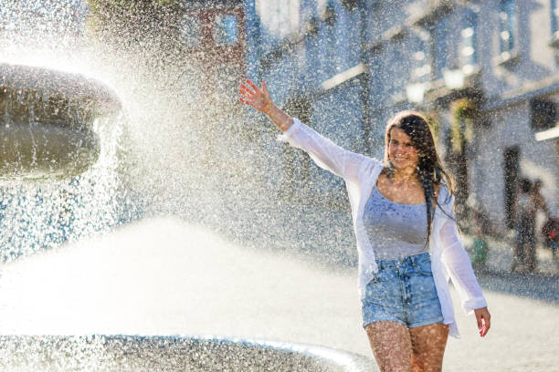 istock Woman having fun with water next to fountain 1681973757