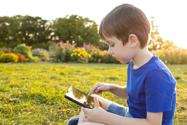 istock A 6 year old boy uses a digital tablet in a city park 1681979721