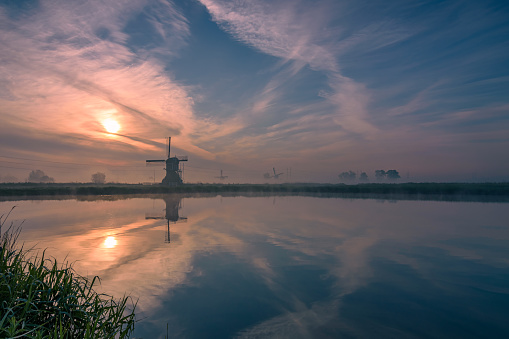 misty sunrise with reflection in a lake