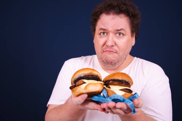istock Funny hungry fat man eating burger. 1681986707