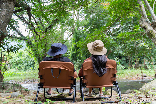 Couple sitting on a chair in a comfortable campsite or country house Informal living in nature. Millennial weekend getaways to overnight stays