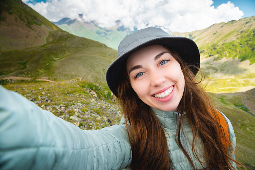 I want to share my journey with everyone. Shot of a young woman taking a selfie while walking in the mountains, natural beauty.