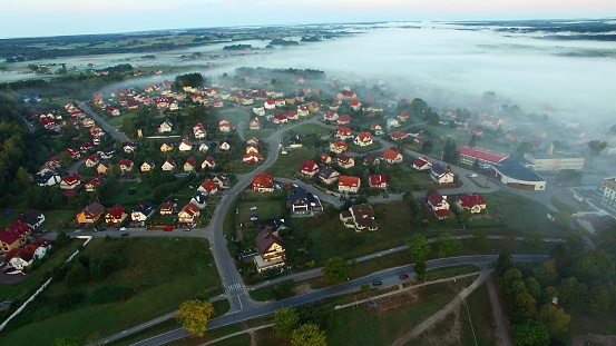 Aerial foggy morning lakeside village and yachts