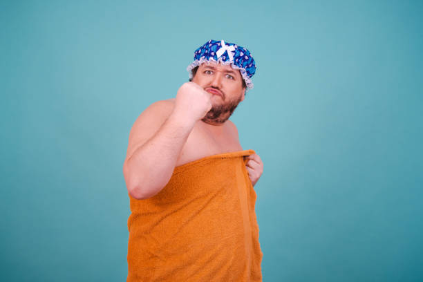 istock Funny fat man is washing himself in the shower. 1682014751