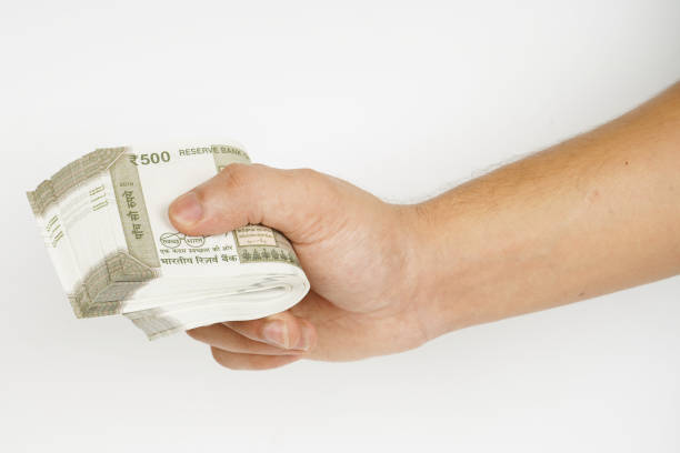 istock Bundle of indian rupees in hand on white background 1682019834