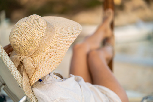 Unrecognizable woman whit sun hat enjoying in summer vacation on the beach