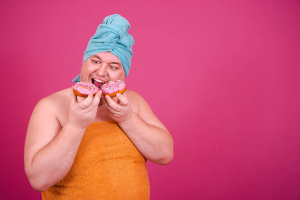 istock The guy wrapped in a towel after a shower poses on a pink background. 1682040164