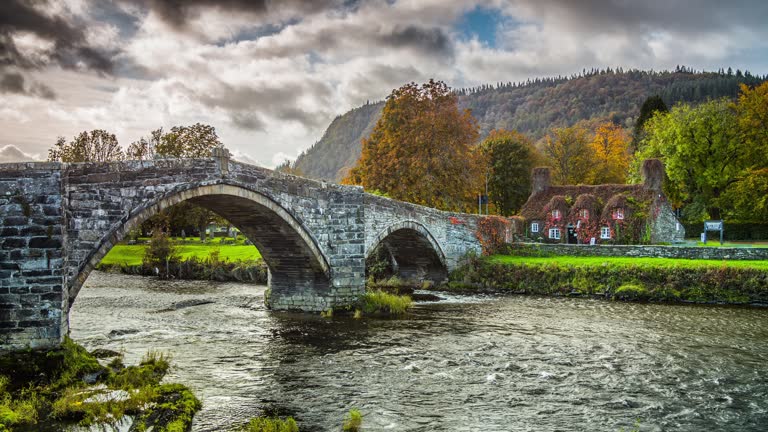 Idyllic landscape with old stone bridge and cottage covered with vine leaves, Llanrwst, Caernarfon, North Wales