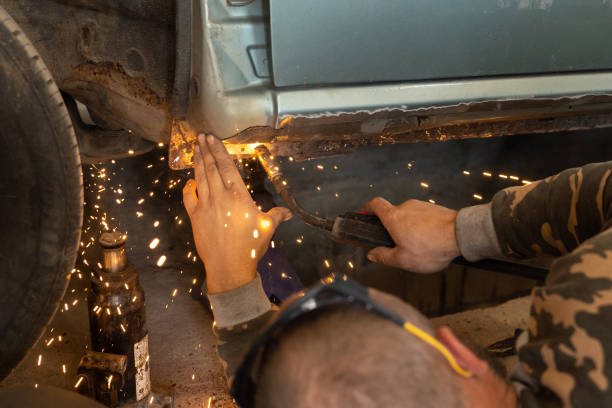 the mechanic uses a welding machine to repair a car threshold. - car bodywork flash imagens e fotografias de stock