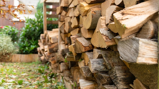 Beech logs are stored in the firewood rack. Outside in front of the house the rack is equipped with a roof against weather conditions.