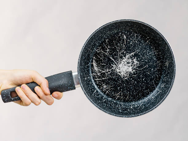 istock Hand holding scratched frying pan 1682077980