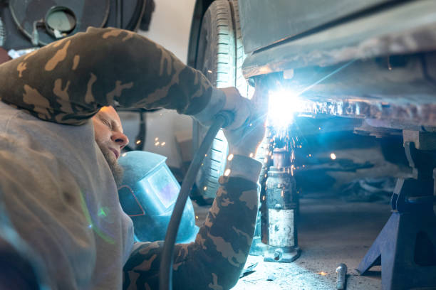 the mechanic uses a welding machine to repair a car threshold. - car bodywork flash imagens e fotografias de stock