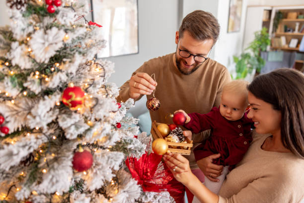 istock Parents decorating Christmas tree with their little daughter 1682134089