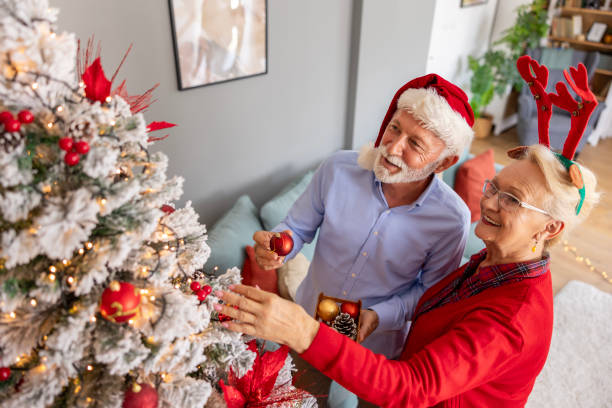 istock Senior couple having fun decorating Christmas tree 1682135160