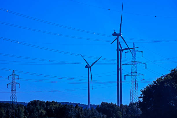 istock windmills with power plants and wires. Economic global crisis 1682146910