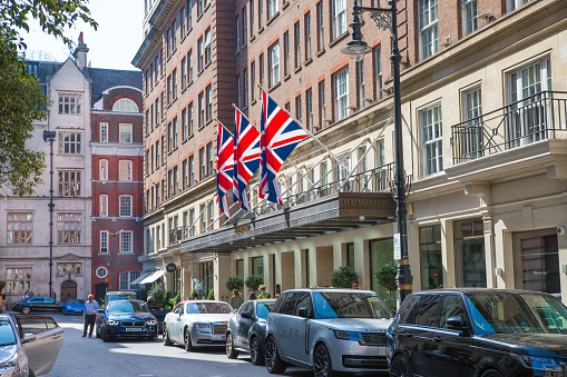 London, UK - 9 September, 2023: Beautiful periodic buildings at Mayfair and luxury cars parked at road. Mayfair one of the richest areas to live with fancy lifestyle