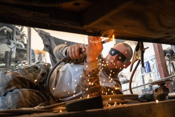 the mechanic uses a welding machine to repair a car threshold. - car bodywork flash imagens e fotografias de stock