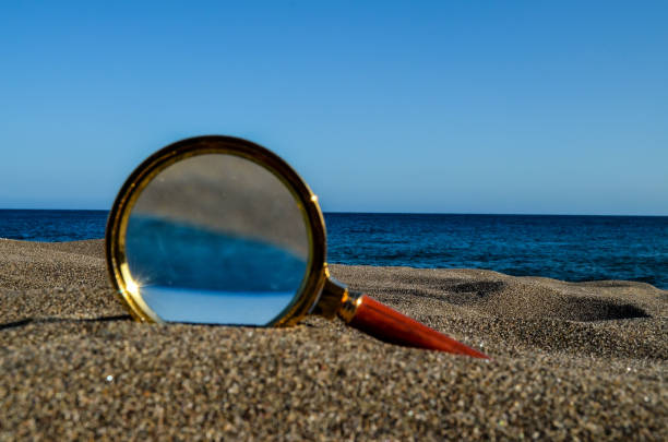 istock Magnify Glass on the Sand Beach 1682159725