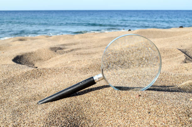istock Magnify Glass on the Sand Beach 1682160314