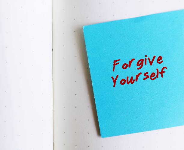 istock Blue note on white copy space background with handwritten text FORGIVE YOURSELF, concept of learning to fully accept whatever you did - let go any resentment you have made significant mistakes 1682165193