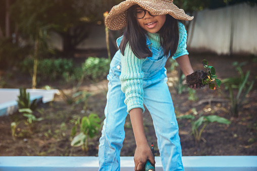 A charming image of a little girl, filled with anticipation and curiosity for her plants