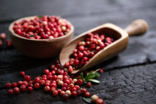 istock Fresh raw cranberry in wooden bowl on rustic table 1682171612
