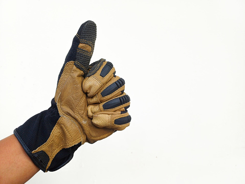Construction worker showing thumbs up sign, isolated on white background.  Hand with Brown leather glove