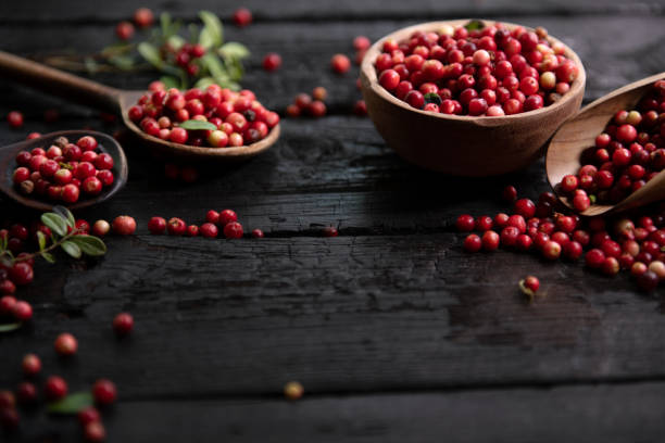 istock Fresh raw cranberry in wooden bowl on rustic table 1682173739