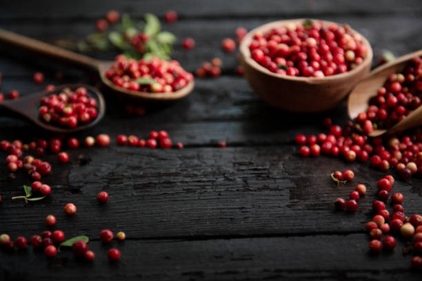 istock Fresh raw cranberry in wooden bowl on rustic table 1682174408