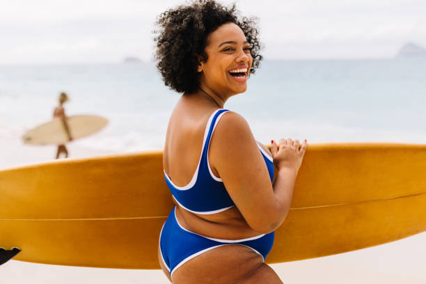 istock Curvy young woman having fun on a surfing vacation at the beach 1682190871
