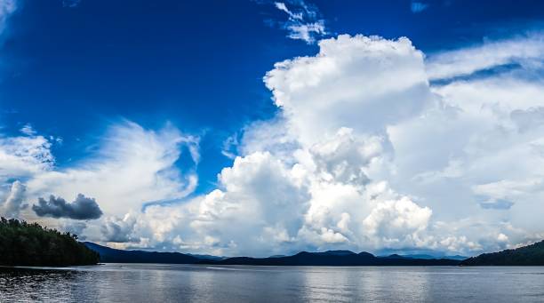 istock Tranquil scene of a lake surrounded by mountains and trees, illuminated by a cloudy sky 1682196155