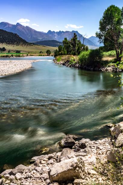 istock Tranquil stream winding its way through a mountain valley, meandering around rocks and lush grasses 1682197322